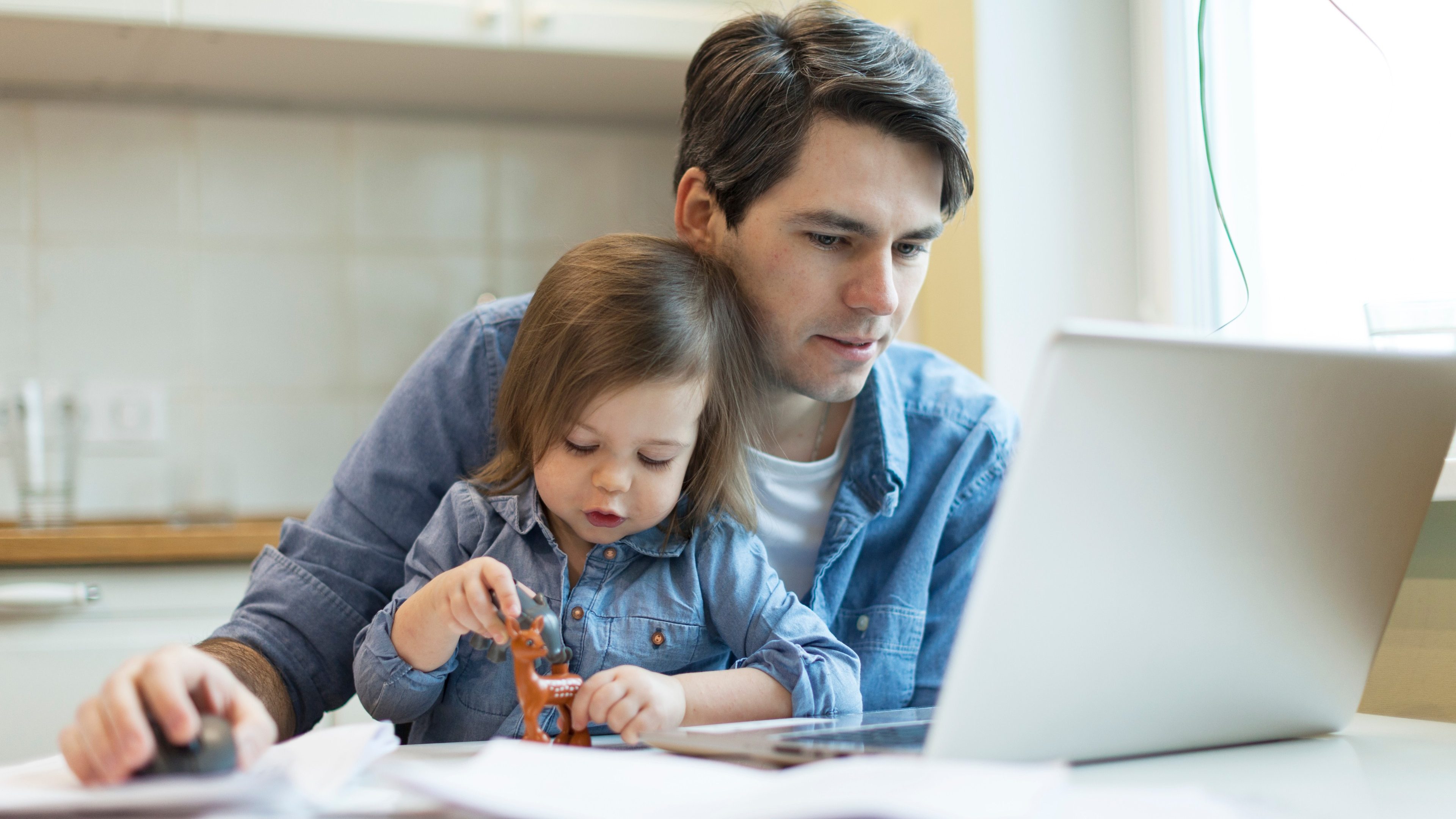 Father working on laptop. businessman working from home and watching children. spending time with kids. Young man working on computer. StartUp. Freelance. successful modern family.