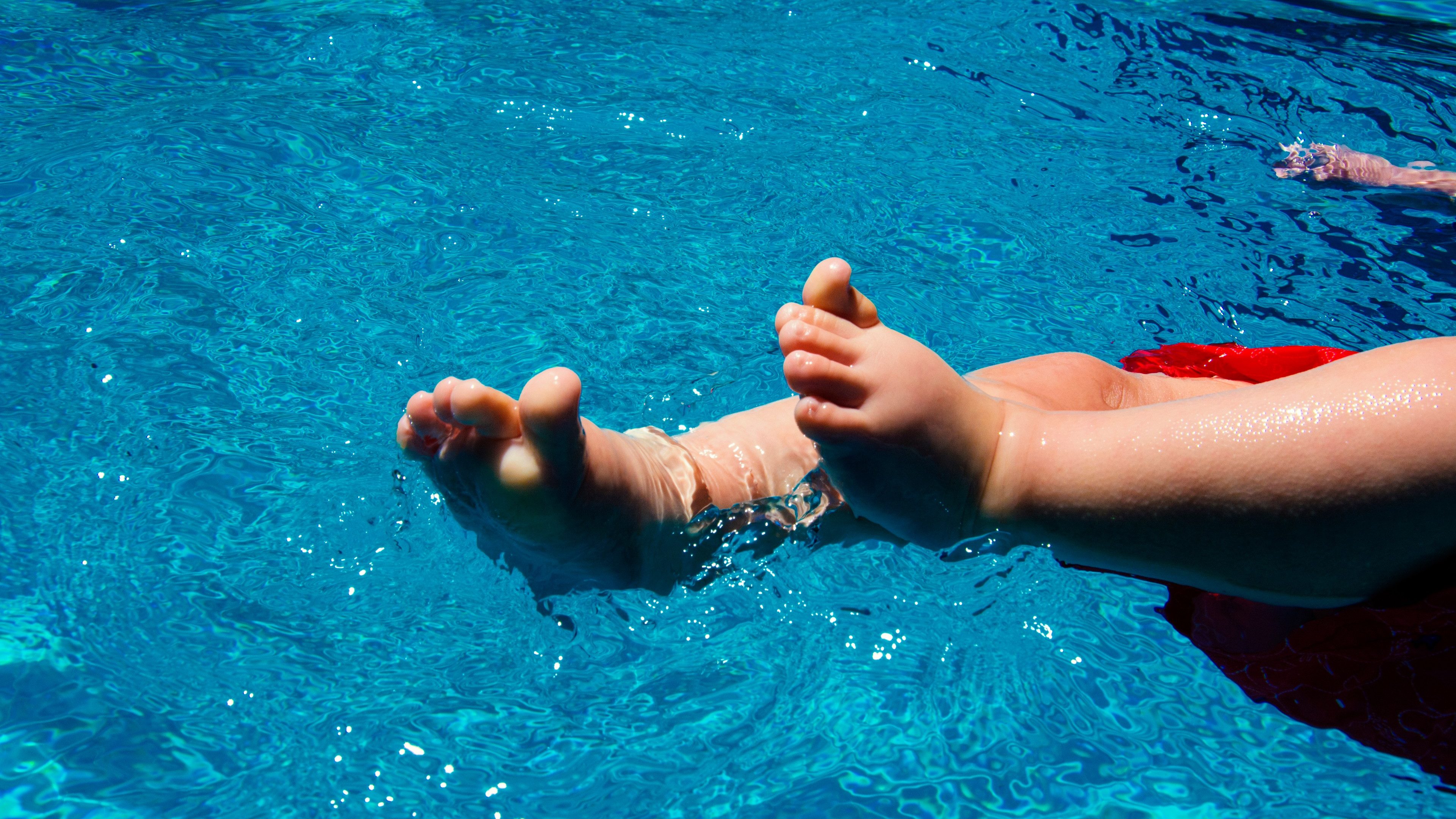 A 6 month old baby relaxing in swimming pool in the summer.